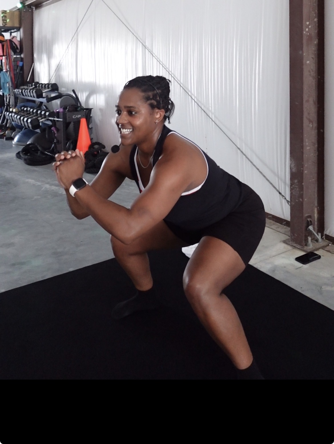 A Legends Xclusive coach demonstrating squat form during a group session